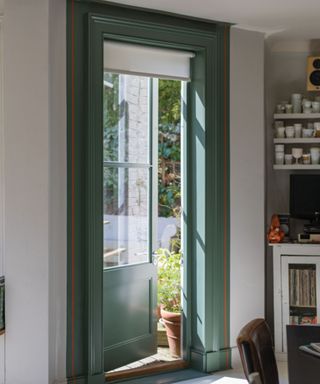 dining space with white walls and door to garden with mid-green door frame