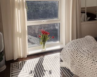 Ruggable in bedroom by window with tulips in window