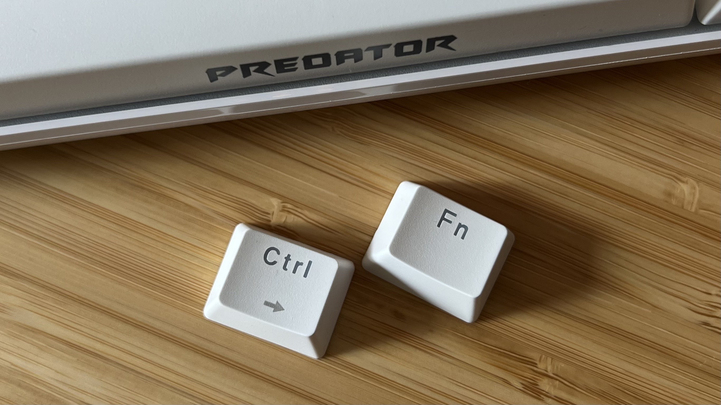 Keycaps from Acer Predator Aethon 330 gaming keyboard, removed from the main deck and placed on a wooden desk