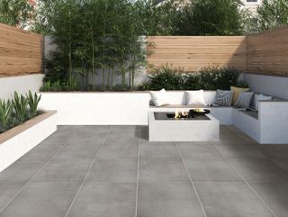 low maintance garden with grey paving and white painted borders