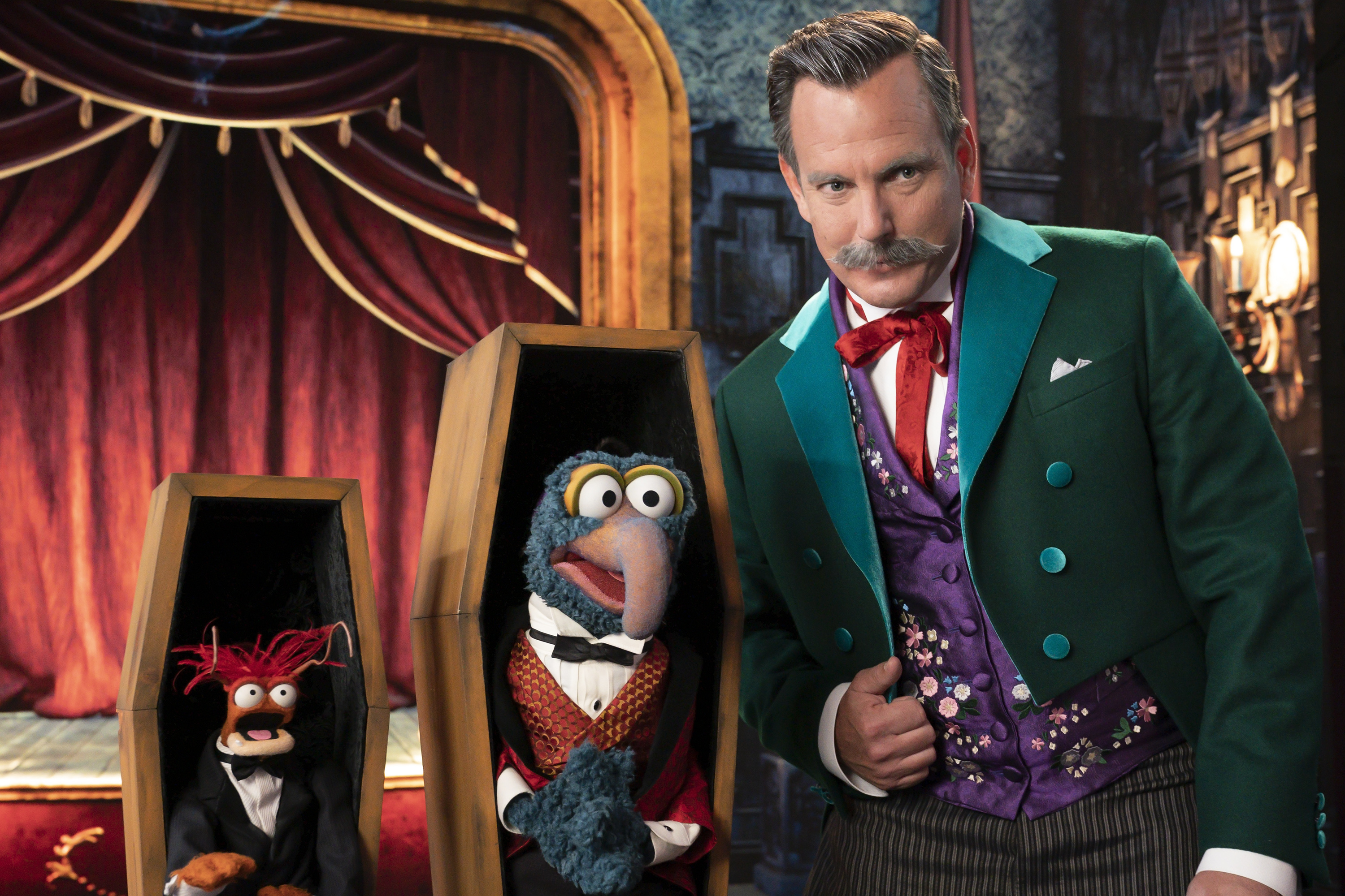Gonzo and Pepe the Prawn pose in coffins with Will Arnett for Muppets Haunted Mansion