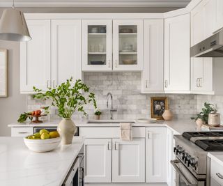 traditional white kitchen with marble subway tiles and stainless steel accessories