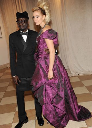 Princess Elisabeth von Thurn und Taxis, pictured at the 2013 Met Costume Institute Gala next to a man in a suit, wears a deep purple dress and Mohican-style hair