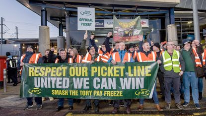 Rail workers holding banners and union flags outside Ashford International Station in Kent