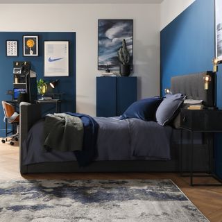 Teenage boys bedroom with blue walls and bed with tv.