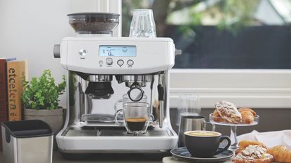 Breville Barista Pro on a countertop with coffee and croissants around it