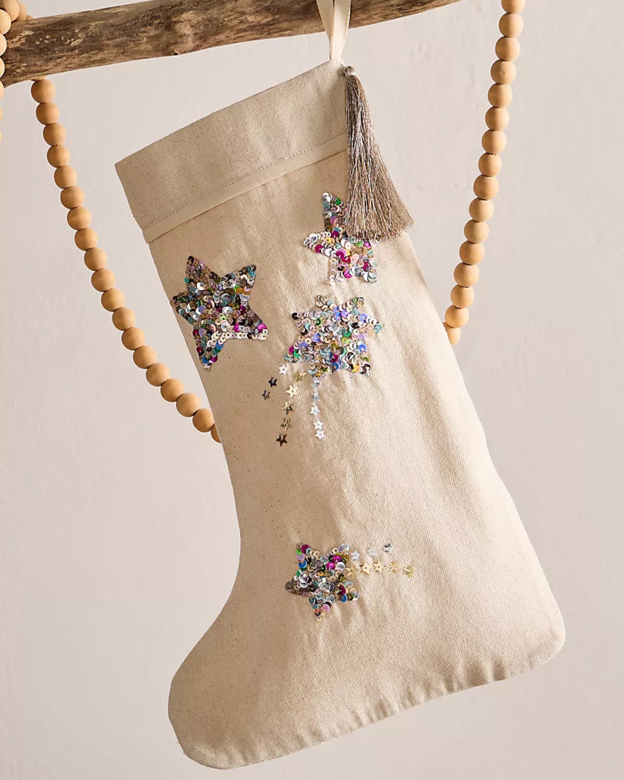 A white canvas Christmas stocking with glitter stars on it