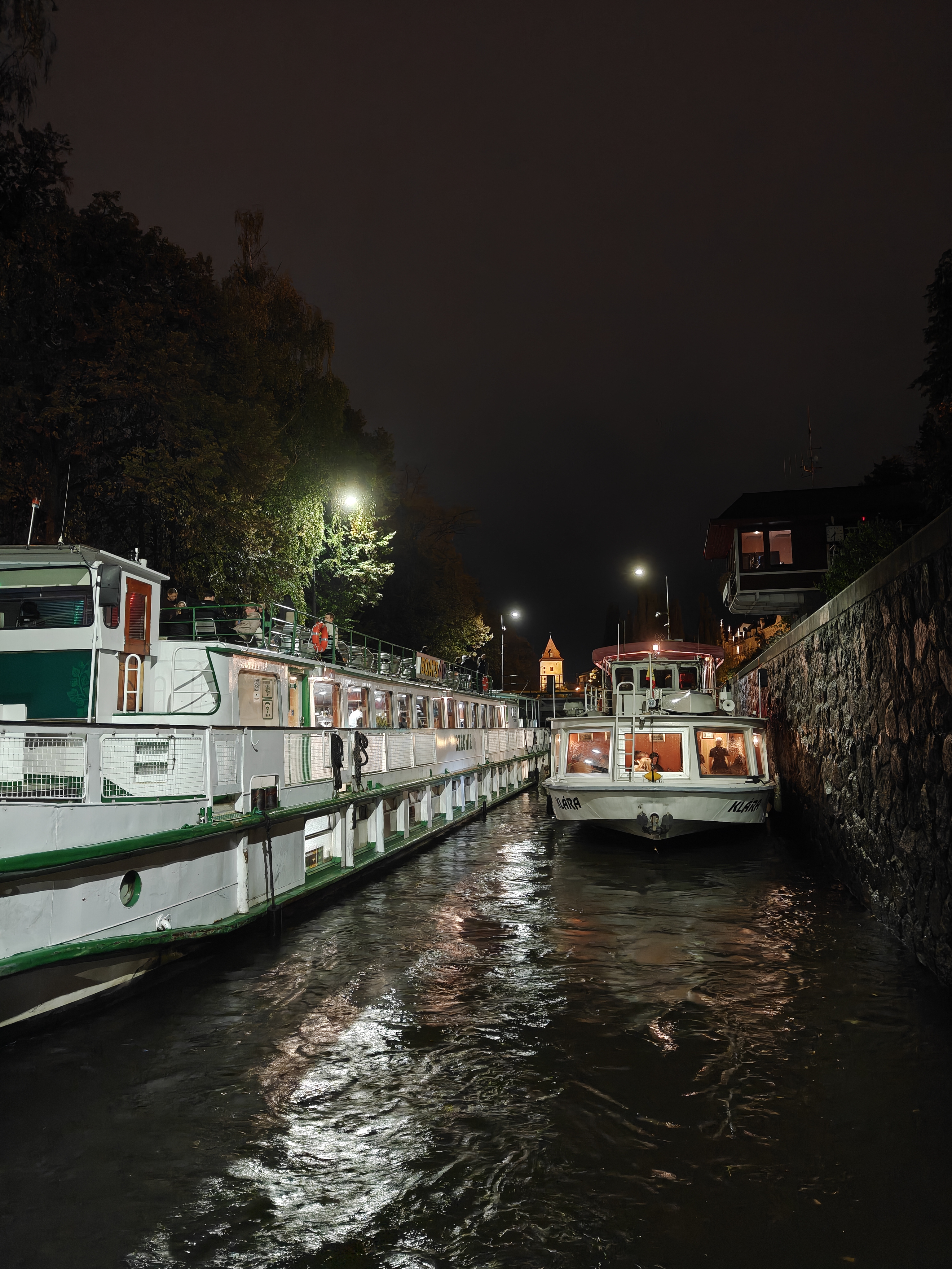 Two boats in the Vltava river at night