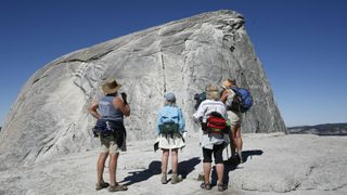 Early in the morning before the crowds arrived, a group of hikers look at the Half Dome cable section in Yosemite National Park