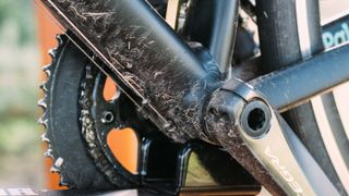 The dirty underside of a black bike's bottom bracket