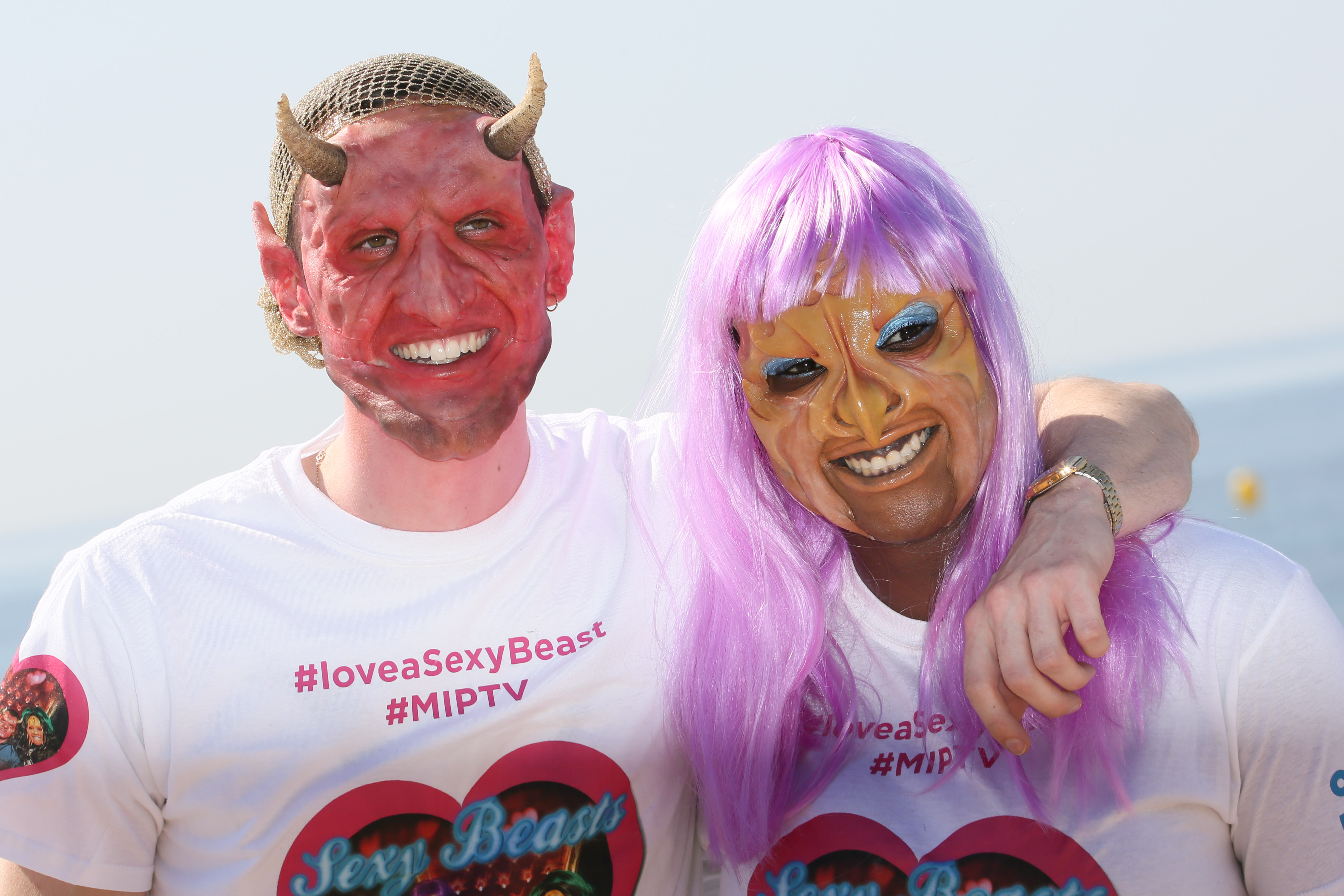 a man in a red devil like mask and a woman with a pink wig and mask in a still for 'Sexy Beasts'