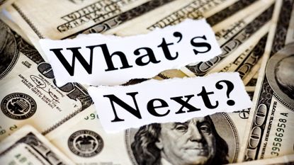 A pile of hundred dollar bills lying underneath a note that reads "What's Next?"