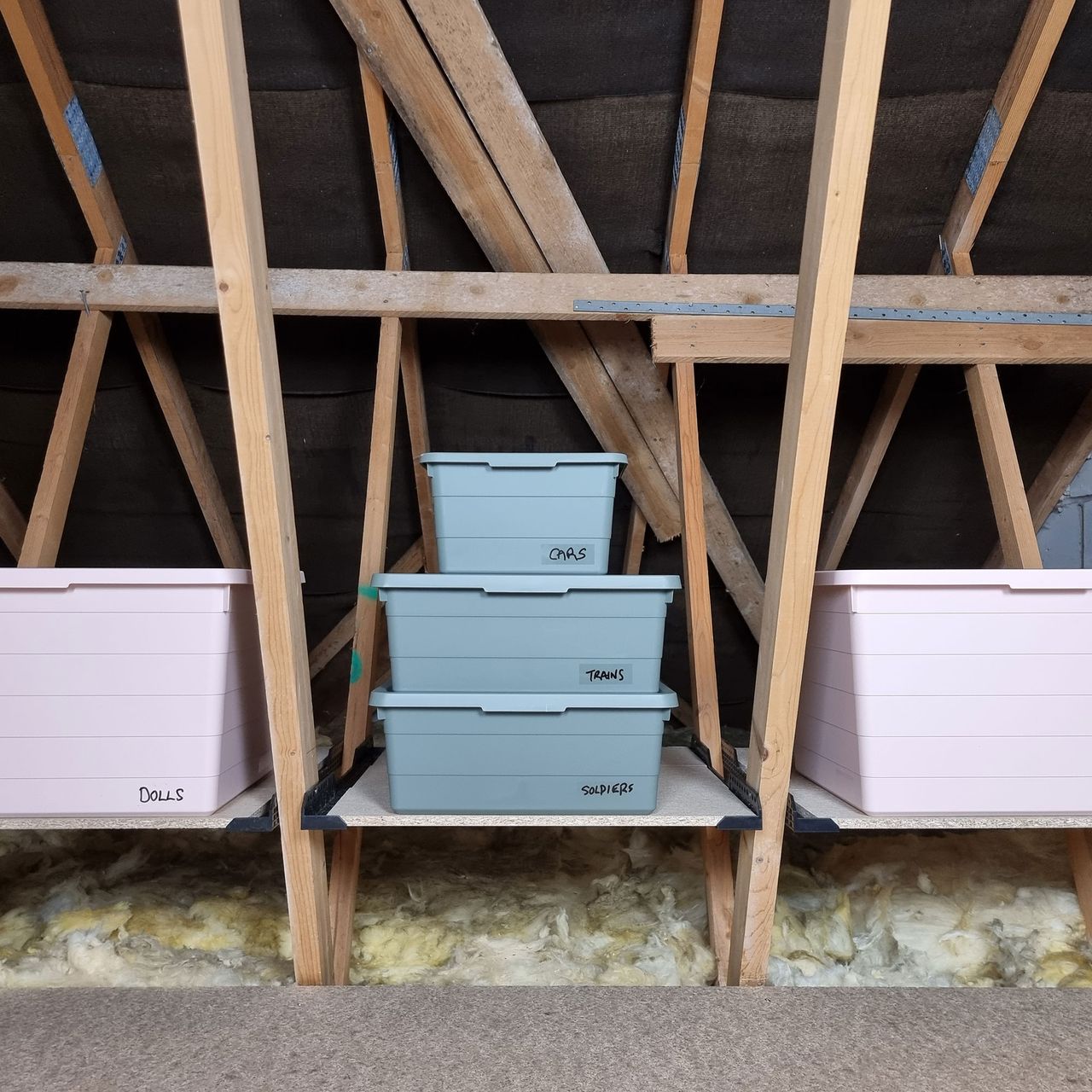 Pink and grey boxes on shelf in attic