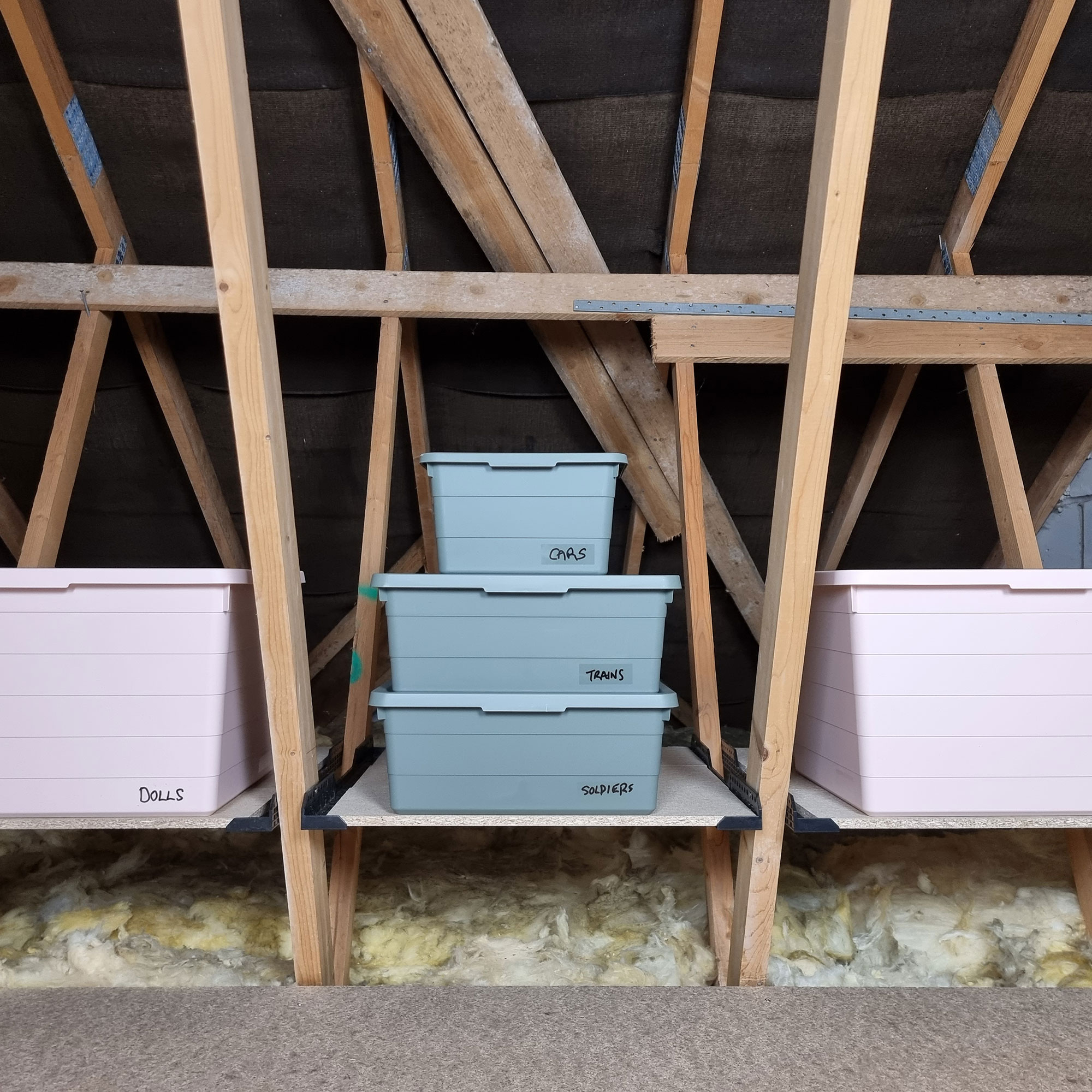 Pink and grey boxes on shelf in attic