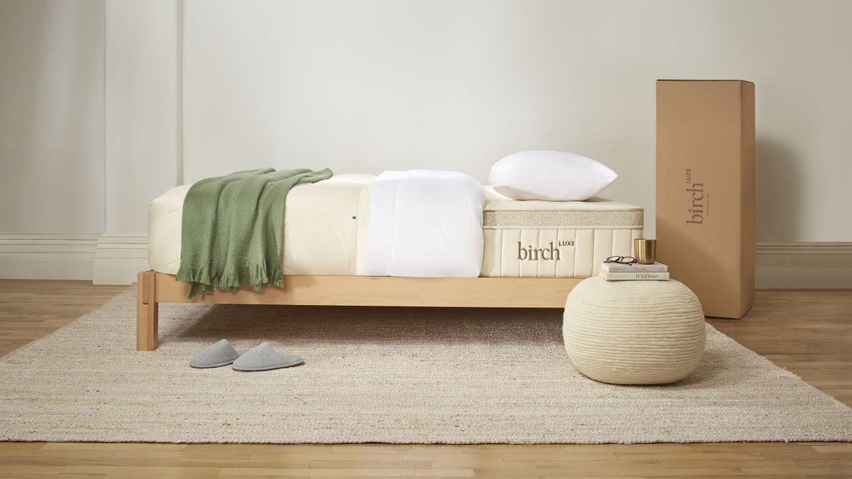 The Birch Luxe Natural Mattress shown on a light wooden bed and dressed with green bed throw