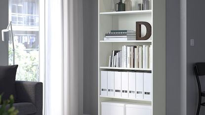 IKEA BILLY bookcase in white, with a window next to it and a black armchair to the left