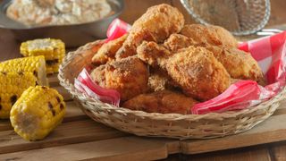 Southern-style fried chicken in a basket with grilled corn and coleslaw