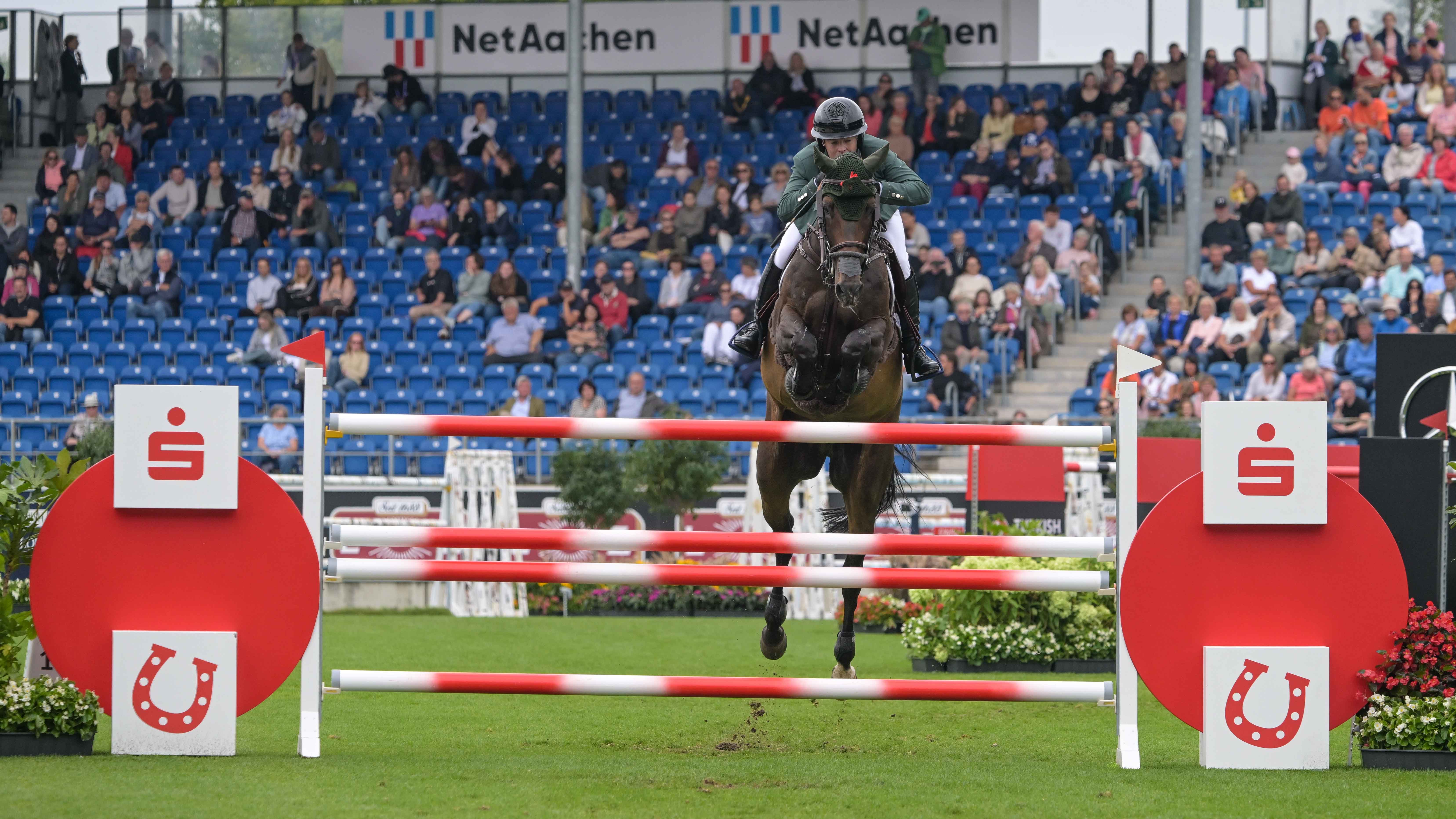 Cian O&amp;rsquo;Connor and Chatolinue PS jump a red and white fence at the showjumping World Championships in Aachen