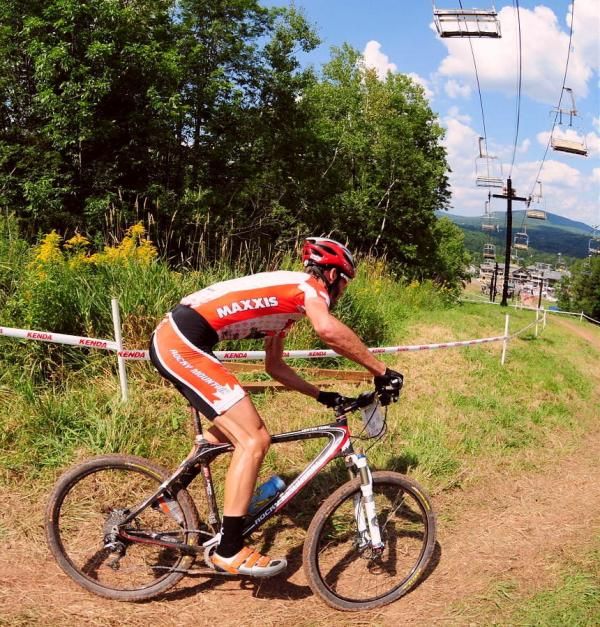 Geoff Kabush (Team Maxxis-Rocky Mountain) rounding a downhill corner with one lap to go