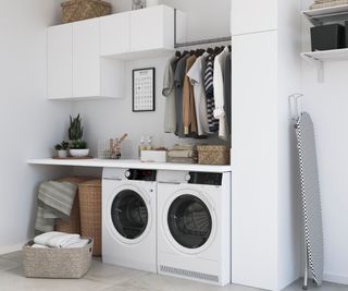 white utility room with washer and tumble dryer placed next to each other under worktop