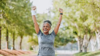 A woman celebrates after running outdoors