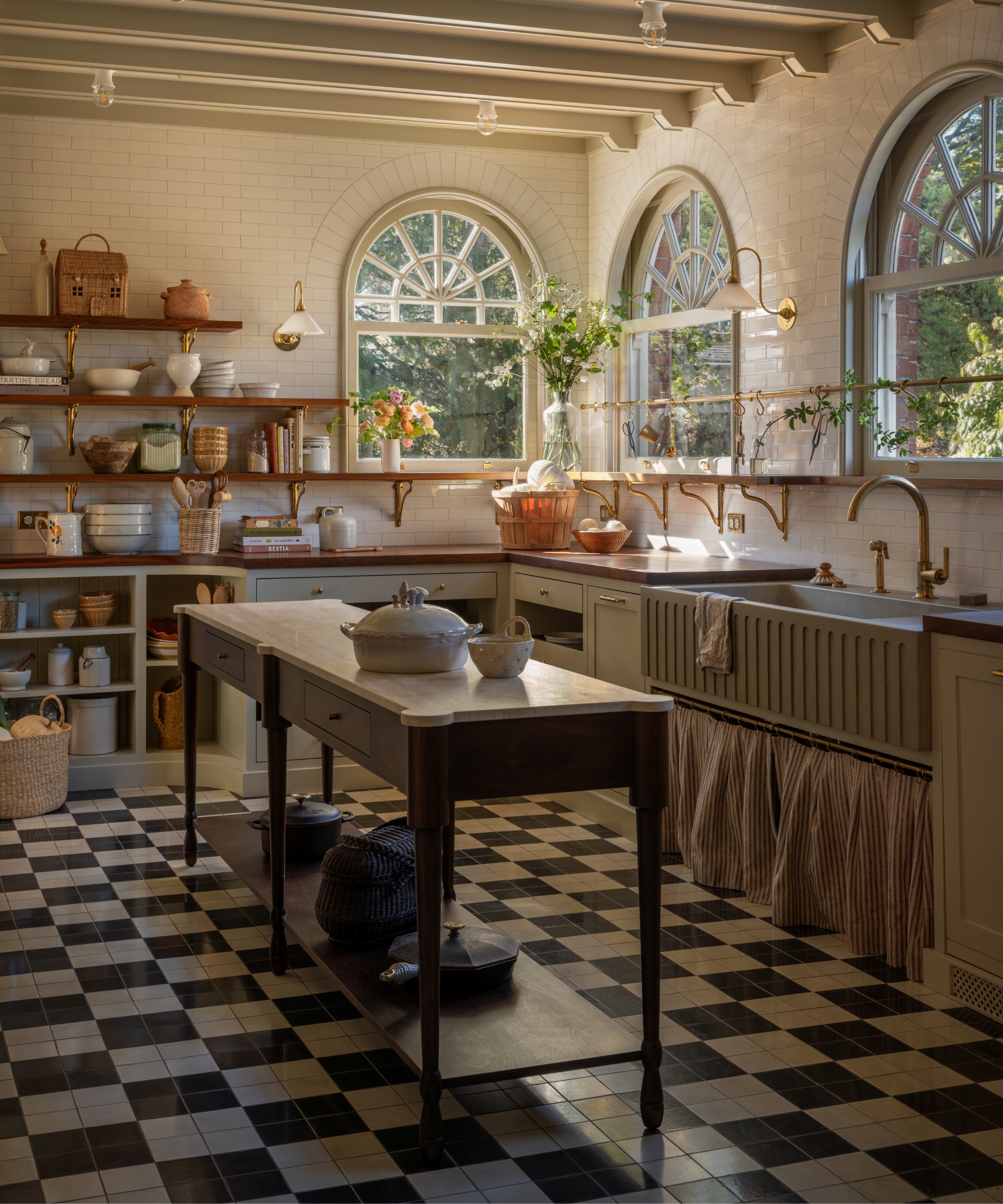a small kitchen with white cabinets, white subway tiles walls, and a narrow freestanding island