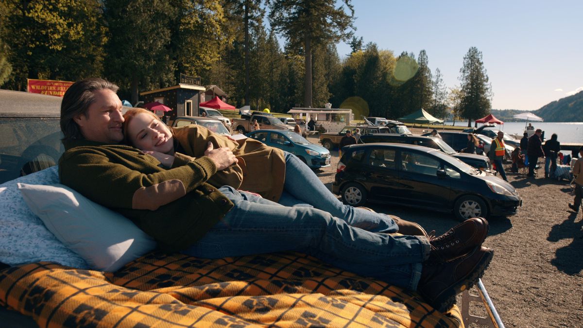 Mel Monroe and Jack Sheridan cuddling on the bonnet of a car in Virgin River season 6.