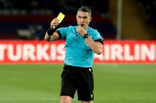Referee Istvan Kovacs of Romania gives a yellow card to Raphinha of Barcelona during the UEFA Champions League quarter-final second leg match between FC Barcelona (Barca) and Paris Saint-Germain (PSG) at Estadi Olimpic Lluis Companys on April 16, 2024 in Barcelona, Spain.(Photo by Jean Catuffe/Getty Images)