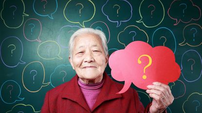 An older Asian woman holds a thought bubble with a question mark on it.