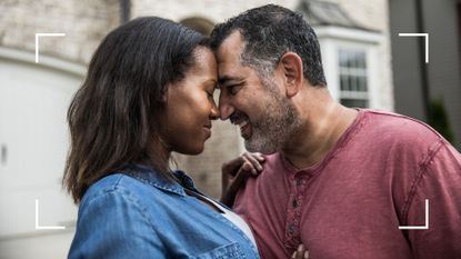 Woman and man standing in front of their house in up-close shot, smiling and leaning their heads together romantically, representing how to boost libido