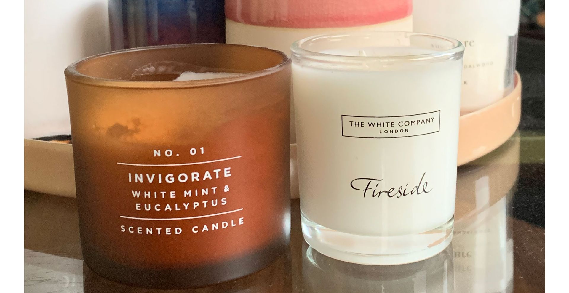 Scented candles on a glass coffee table to show an inexpensive way to make your home smell good