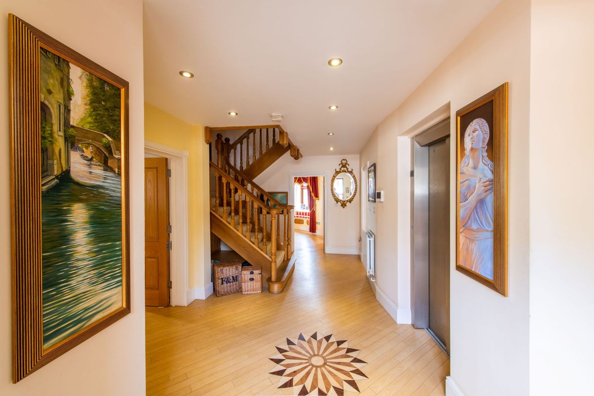 The entrance hallway leads to a wooden staircase and also has a lift opposite both leading to the bedrooms