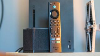 Amazon Fire TV Cube (2022) with Alexa Voice Remote propped against it