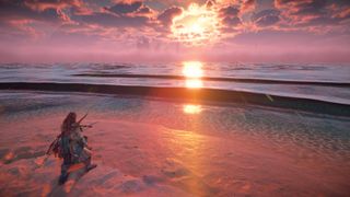 Aloy looks at the sea with the sun over it in Horizon Forbidden West