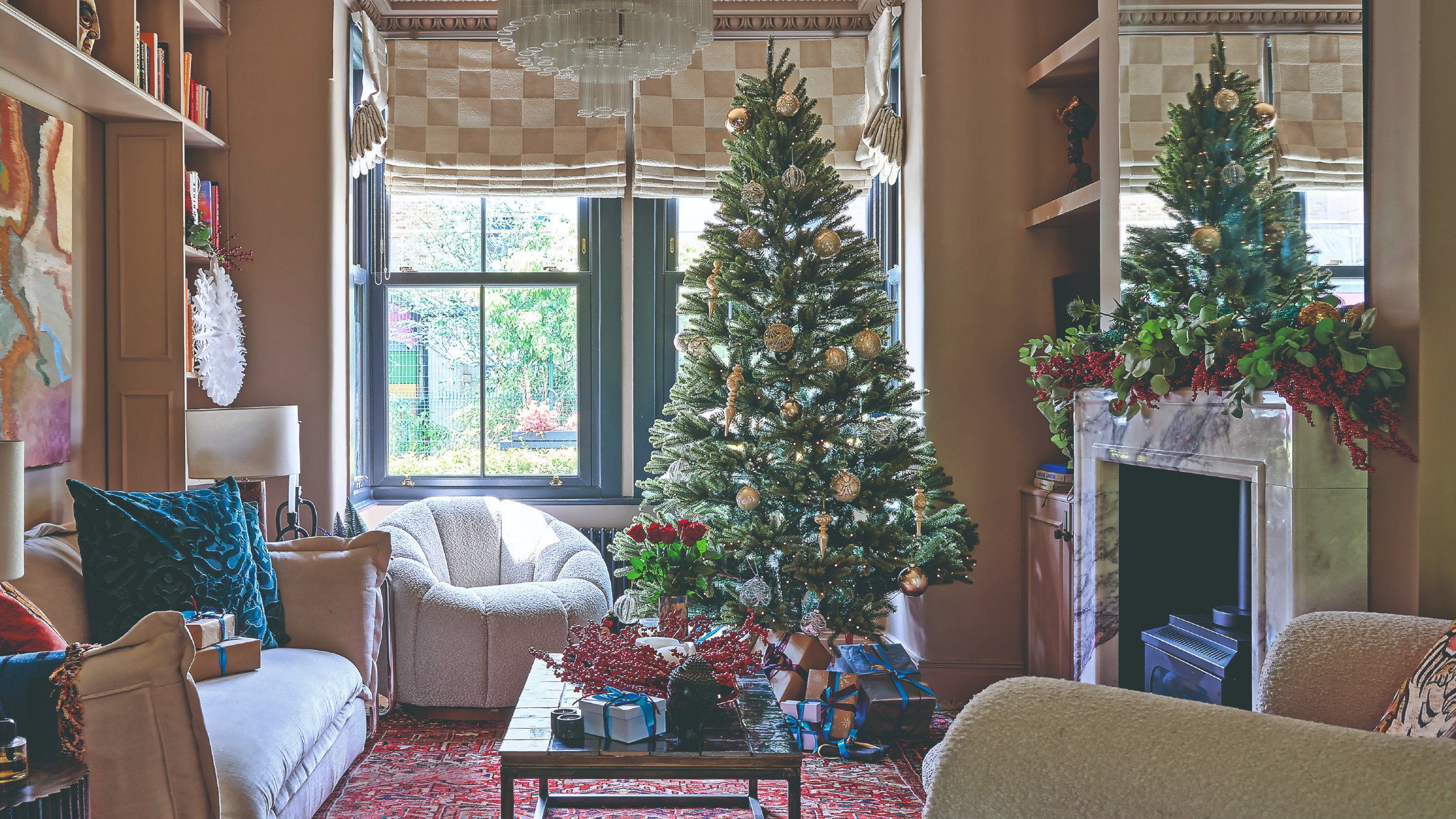 A living room decorated for Christmas with a traditional green Christmas tree in the middle