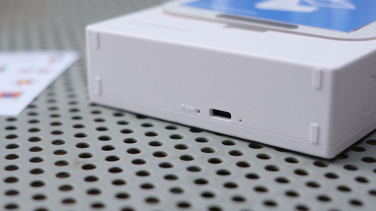 Photograph of Polaroid Hi-Print 3x3 mini instant printer with charging port visible