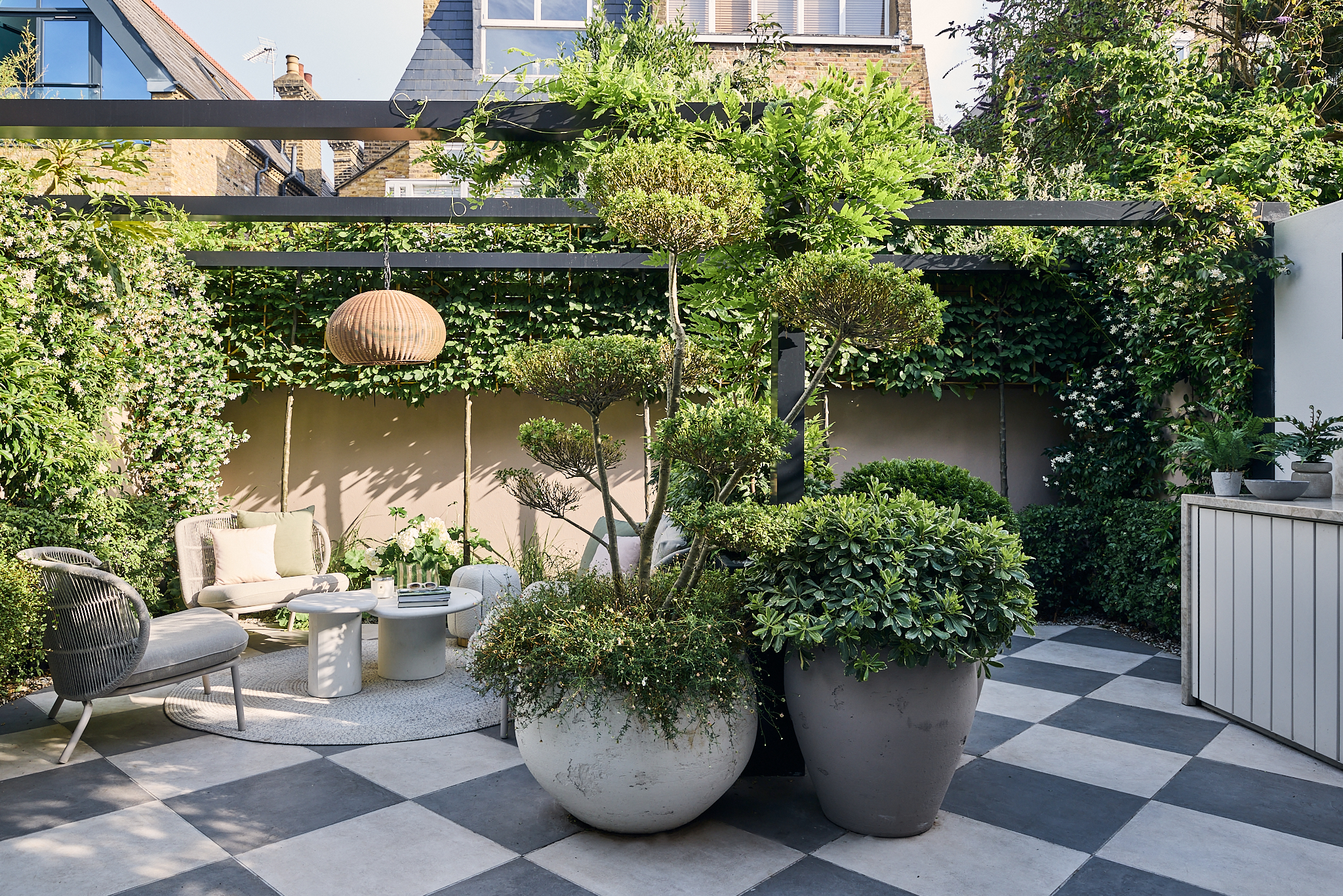 a modern garden filled with plants with a large checkerboard floor