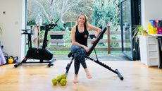 Woman sits on weight bench in domestic setting
