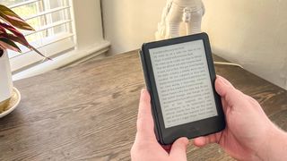 Amazon Kindle (2022) held in hand at a desk while open to an ebook page of text