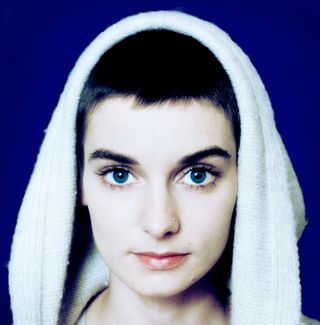 Sinead O'Connor with a with a white robe over her head