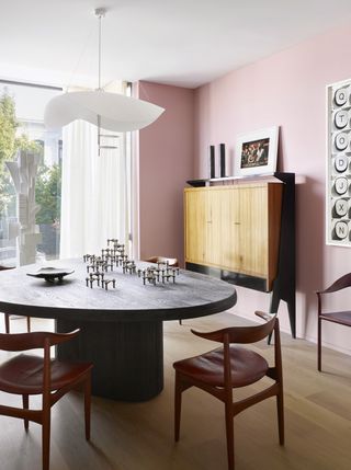 A dining room with light pink walls