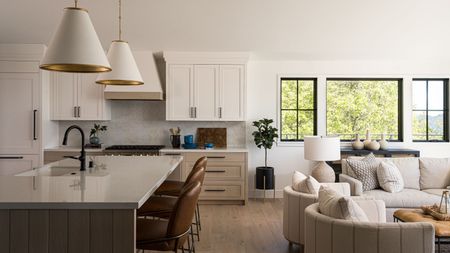 a wood and white kitchen with black hardware and brass lights