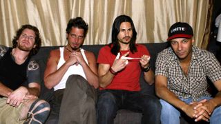 Rock supegroup Audioslave seated on a couch
