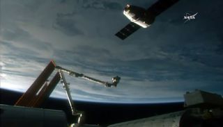 A recycled SpaceX Dragon cargo ship approaches the International Space Station on Dec. 17, 2017 to be captured by astronauts via a robotic arm. It is the second delivery flight to the station for the Dragon capsule.