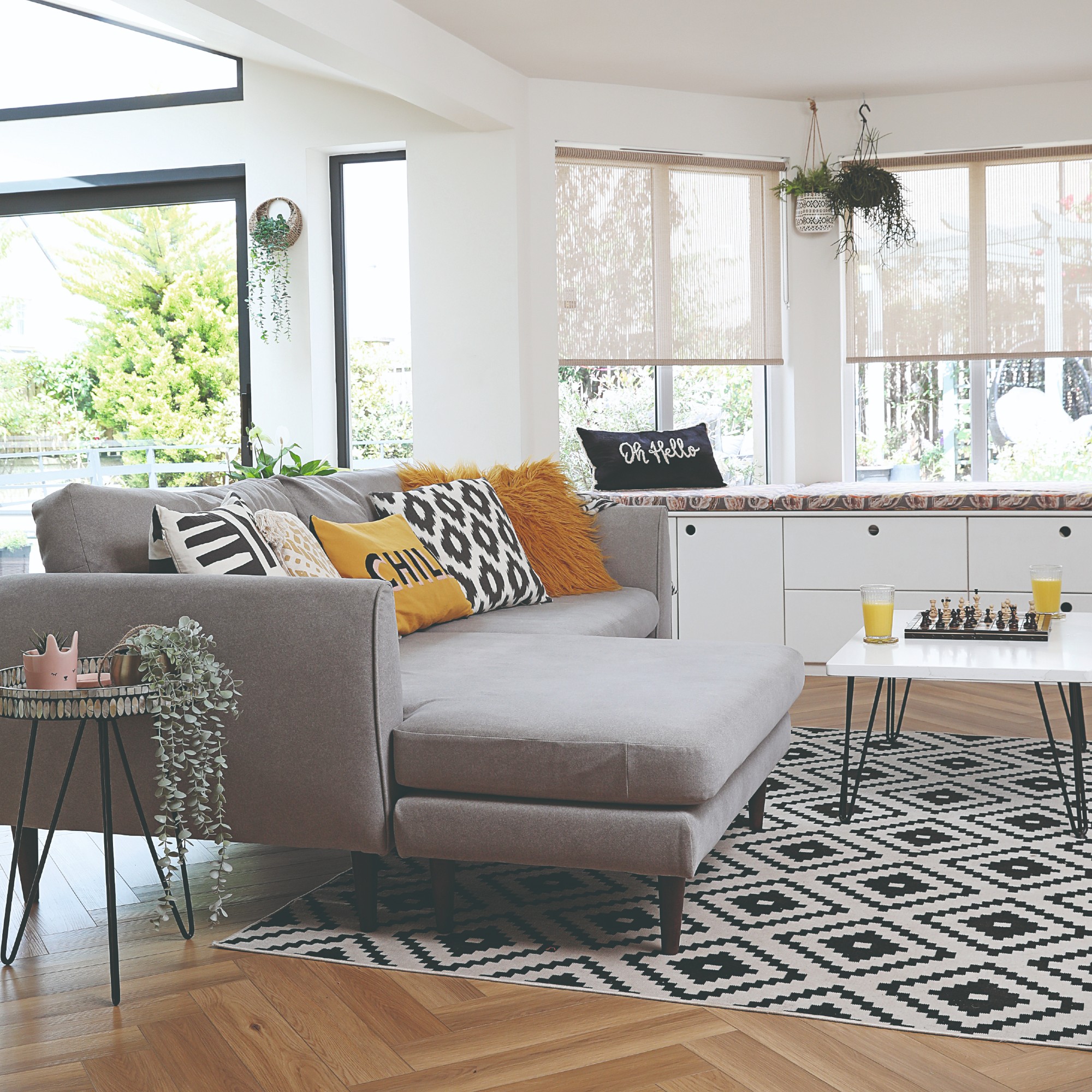An open-plan living room with a grey L-shaped sofa
