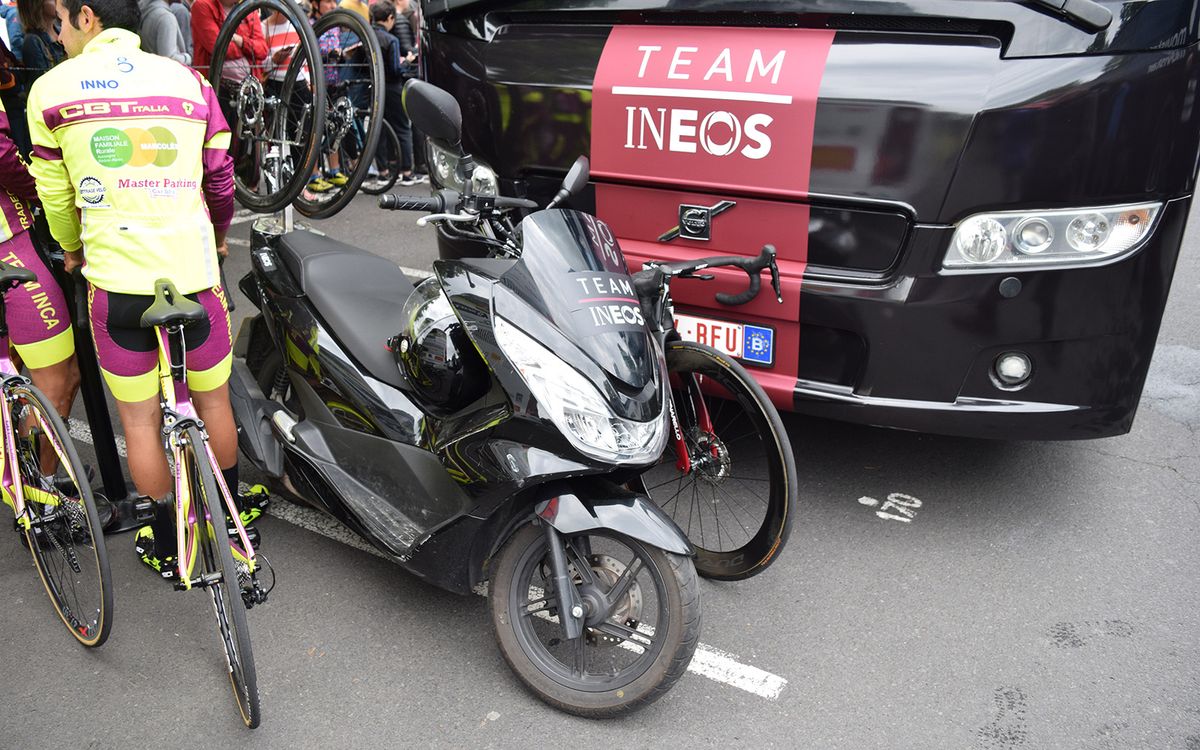 Team Ineos have a member of support staff following the race on a scooter