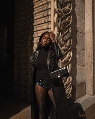 coco bassey wearing sequin hot pants and a trench coat