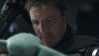 Pedro Pascal looks down sadly with his helmet taken off in The Mandalorian S2 E8 - "Chapter 16 The Rescue."