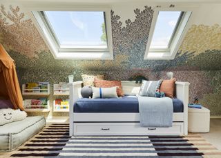 A kids' bedroom with a bed couch under two big skylights