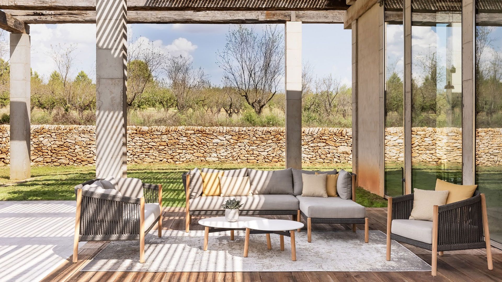 Luxury outdoor patio with corner sofa armchairs and coffee table as part of the outdoor living room garden trend
